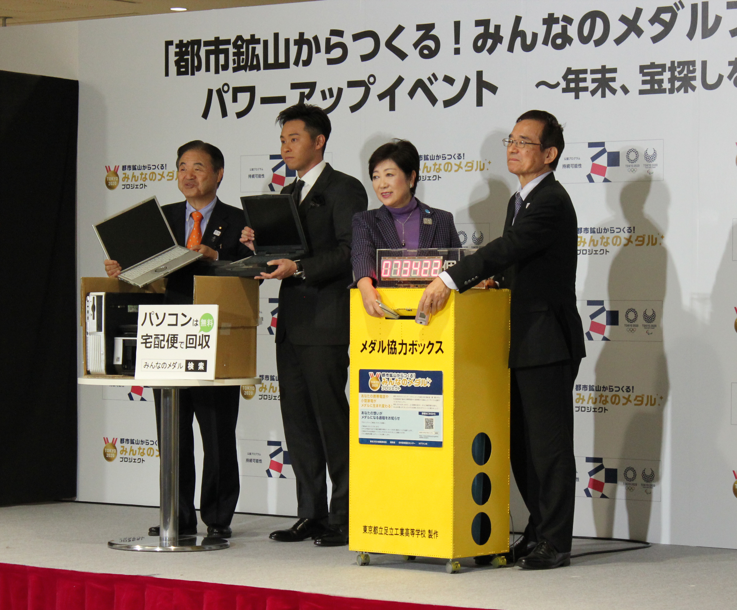 携帯電話をボックスに投入する南川理事長（右）